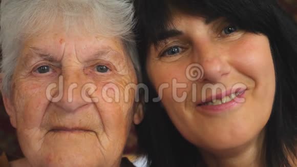 老妇人和她成年女儿对着镜头表现出快乐的情绪的肖像快乐的女人微笑视频的预览图
