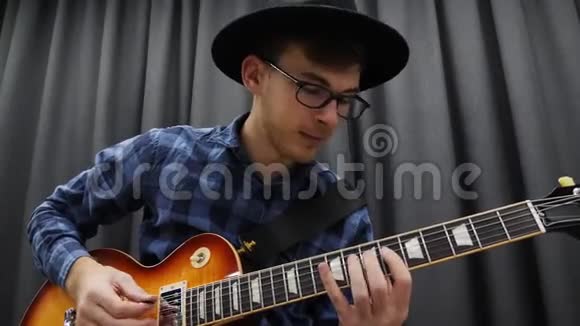 音乐家弹吉他关门年轻可爱的男人拿着皮夹用电吉他独奏音乐课音乐剧一视频的预览图