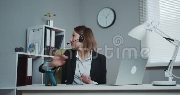 商务女前台戴耳机视频会议用笔记本电脑打电话在线聊天用摄像头聊天视频的预览图