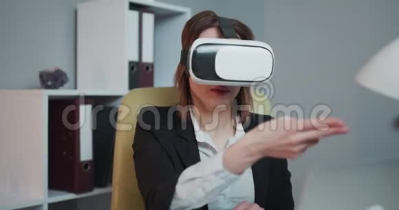 现代商界女性在办公室里戴着虚拟现实眼镜年轻女孩在办公室里用VR护目镜漂亮女人视频的预览图