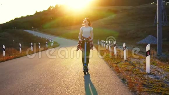夕阳西下的年轻女子骑着电子滑板车慢悠悠视频的预览图