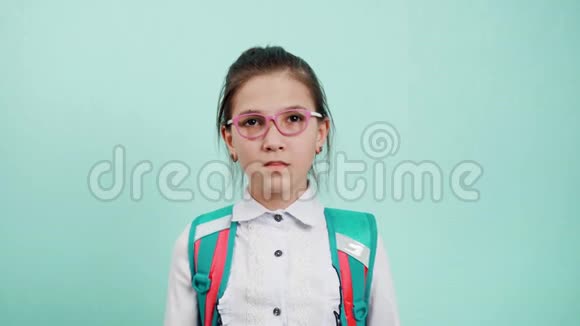 一个穿着白色衬衫戴着粉红色眼镜的女学生的肖像女孩惊讶地抓住她的双手在两颊视频的预览图