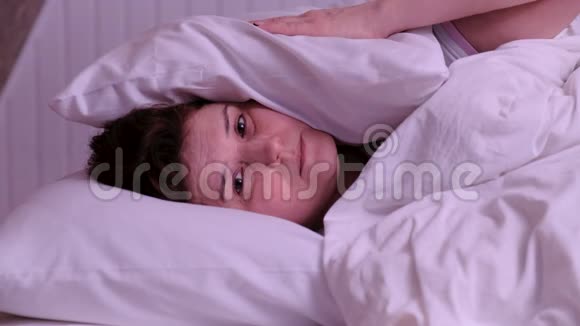 女人睡觉时被闹哄哄的房间邻居用枕头捂住耳朵醒来后躺在床上受苦视频的预览图