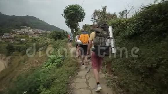 白人游客徒步旅行者背包徒步旅行在尼泊尔尼泊尔村后方视野女人男人视频的预览图