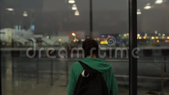 一个年轻的女孩一个晚上在飞机机场等待和拍照的女人后方视野视频的预览图