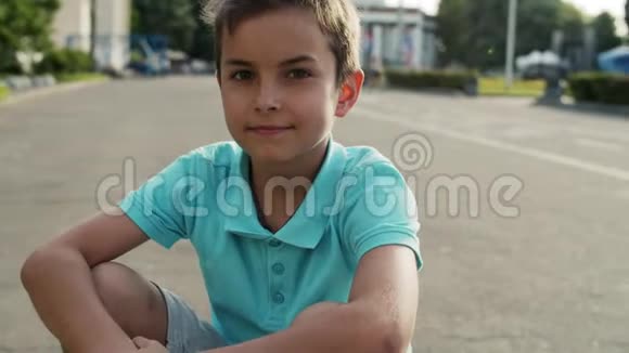 坐在游乐园的可爱男孩把放松的少年关在外面视频的预览图