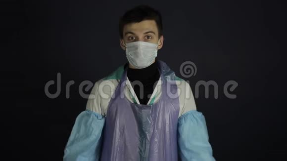穿着医疗服和面具跳舞的疯狂医生孤立的黑色黑暗的背景很开心冠状病毒Covid19视频的预览图