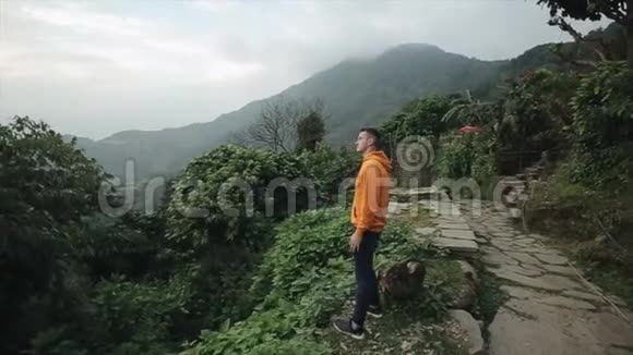 一位白种人游客站在尼泊尔的一座山的边缘山地景观视频的预览图