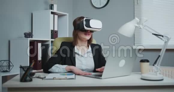 商务女性在办公室戴虚拟现实眼镜年轻女孩在办公室里用VR护目镜是个漂亮女人视频的预览图