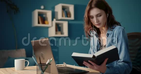 严肃的女士带着笔记本电脑和书在家学习视频的预览图