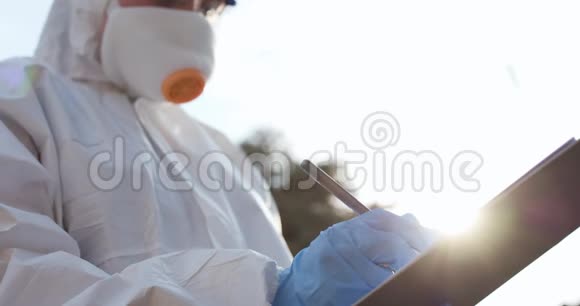 病毒学家用一只白色手套把一支钢笔放在一张白纸上医生拿着一块空白的剪贴板视频的预览图