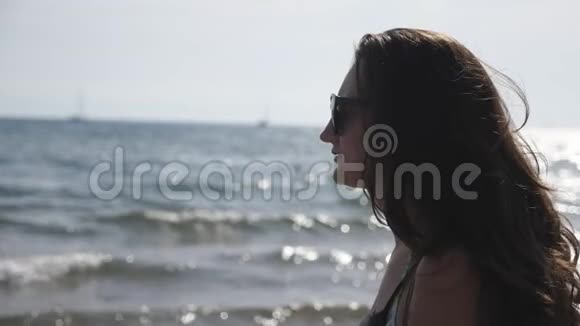 女性旅行者在海洋海岸漫步欣赏美丽的景色深色头发的女人享受着平静的田园诗视频的预览图