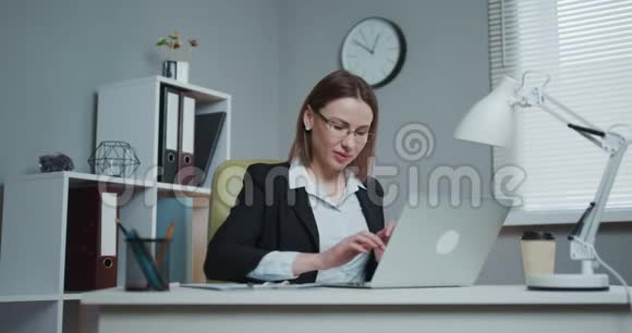 商务女性坐着笔记本电脑和幸福的微笑女专业取得胜利快乐的女人上网视频的预览图