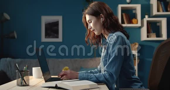在家用电脑和耳机学习的累女孩视频的预览图