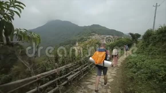 白人游客徒步旅行者背包徒步旅行在尼泊尔尼泊尔村后方视野女人男人视频的预览图