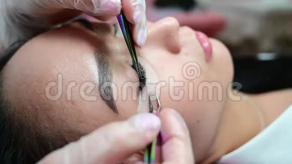 一位美丽的亚洲女人的睫毛延伸程序特写双卷假睫毛拉什制造者在工作视频的预览图