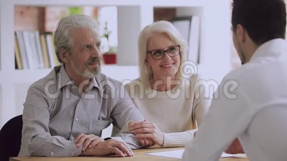 幸福的老夫妇客户签订保险合同握手律师视频的预览图