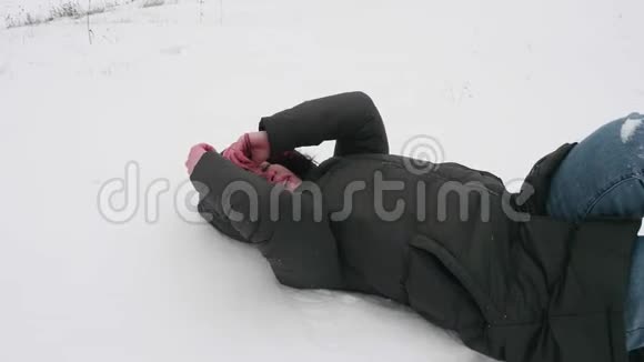 女人躺在雪地上她用手保护她的脸然后男人手抓住她视频的预览图