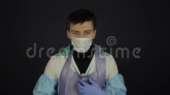 一个年轻的白种人咳嗽戴着医疗面具孤立的黑色背景冠状病毒COVID19视频的预览图