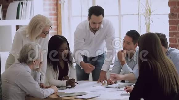 商务团队的人在会议上集思广益地解决文书工作中的错误视频的预览图