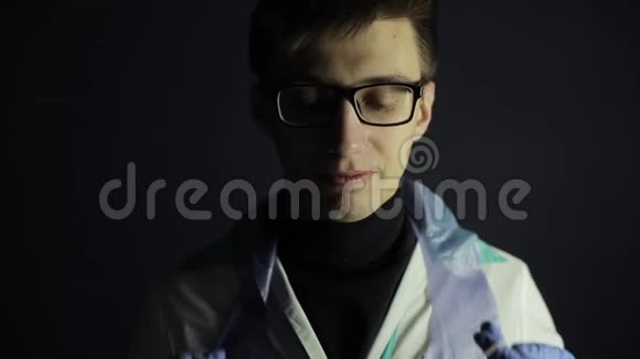 一位年轻的白种人医生戴着医用防护面罩竖起大拇指暗黑背景医用手套视频的预览图