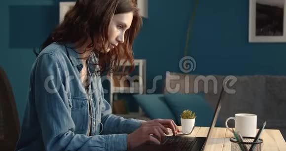一位微笑的女士坐在桌子旁在电脑上工作视频的预览图