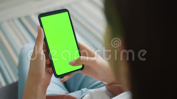慢动作的女孩手握智能手机与色度键绿色屏幕视频的预览图