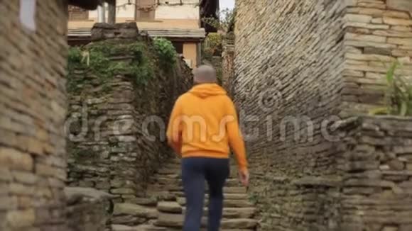 一个白种人走在狭窄的尼泊尔石街上尼泊尔加德满都山村视频的预览图