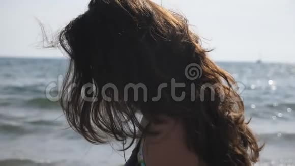 女性旅行者漫步在海洋海岸欣赏美丽的景色深色头发的女人享受平静的田园时刻视频的预览图