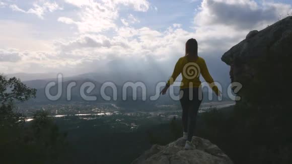 年轻女子在悬崖的尽头举起双手视频的预览图