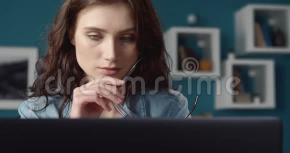 客厅用笔记本电脑工作的黑发女孩画像视频的预览图