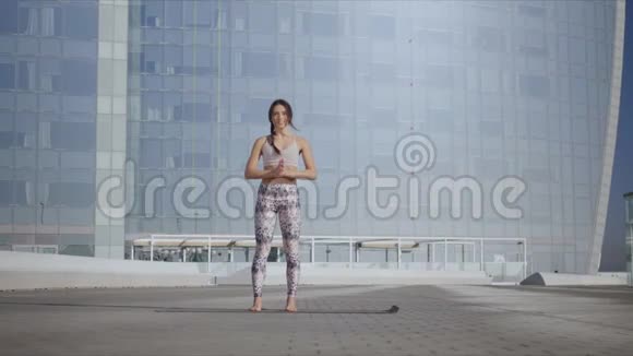 女人在城市大街上伸展身体在城市做瑜伽的运动女孩视频的预览图