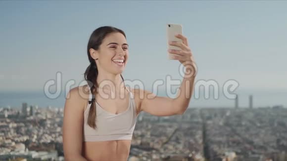 女运动员通过视频电话与朋友在线交谈反对巴塞罗那市视频的预览图