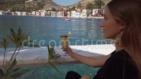 美女坐在水边喝着菠萝汁视频的预览图