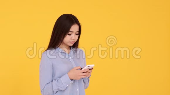 女孩没有感情不高兴发短信电话黄色背景的女人视频的预览图