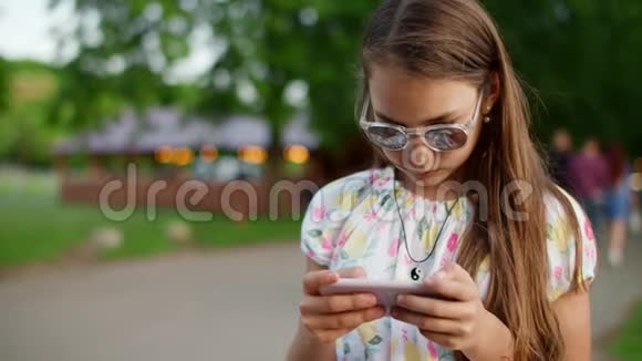 专注的少女看智能手机严肃的女孩在手机上看新闻视频的预览图