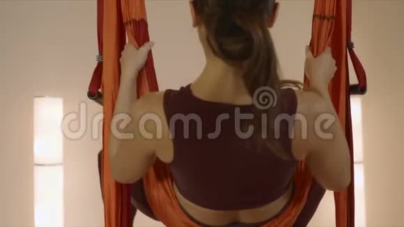 在飞行瑜伽课上做倒明星姿势的女人女士在吊床上练习瑜伽视频的预览图