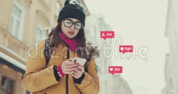女孩打字智能手机冬季外观与雪背景社交媒体图标与类似评论跟踪计数器快速视频的预览图