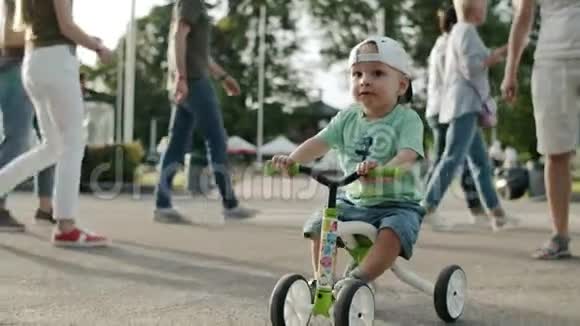 在游乐园里专注的幼儿小男孩在外面骑自行车第一次尝试视频的预览图