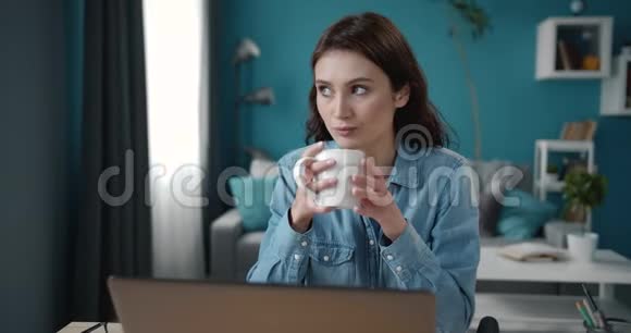 自信的女人在笔记本电脑上休息喝咖啡视频的预览图