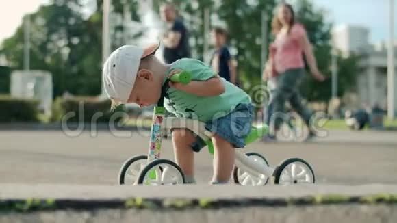 专注的孩子第一次尝试自行车可爱的男孩在游乐园骑自行车视频的预览图