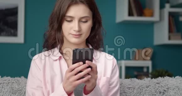 微笑的女人用智能手机和朋友聊天视频的预览图