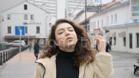 多云天气下市中心一个棕色头发的漂亮女孩的脸视频的预览图