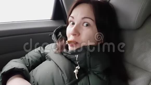 漂亮的微笑黑发在汽车后座与锥冰的末端在嘴融化的冰淇淋掉在外套上当她看到视频的预览图
