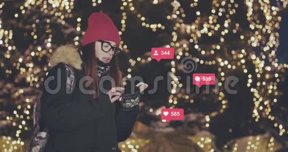 女子在夜城街道行走时使用手机年轻女子发短信在手机户外交流视频的预览图