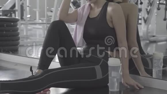 美丽的年轻亚洲女人在健身房锻炼后疲惫疲惫亚洲女孩有汗水和呼吸休息视频的预览图