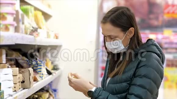 戴着医用口罩的年轻女子在超市买牛奶视频的预览图