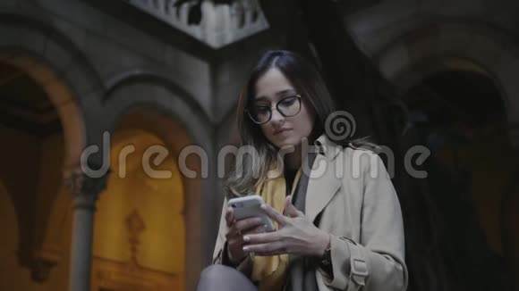 学生在大学里使用智能手机女商人在外面打手机视频的预览图
