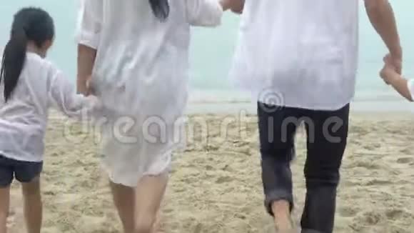 快乐的亚洲家庭一起在海滩上跑步放松视频的预览图