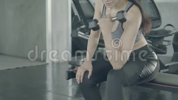 美丽的年轻亚洲女性在健身房锻炼身体在健身时锻炼身体锻炼哑铃视频的预览图